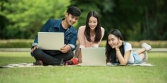 Three students of Chinese heritage looking at laptop
